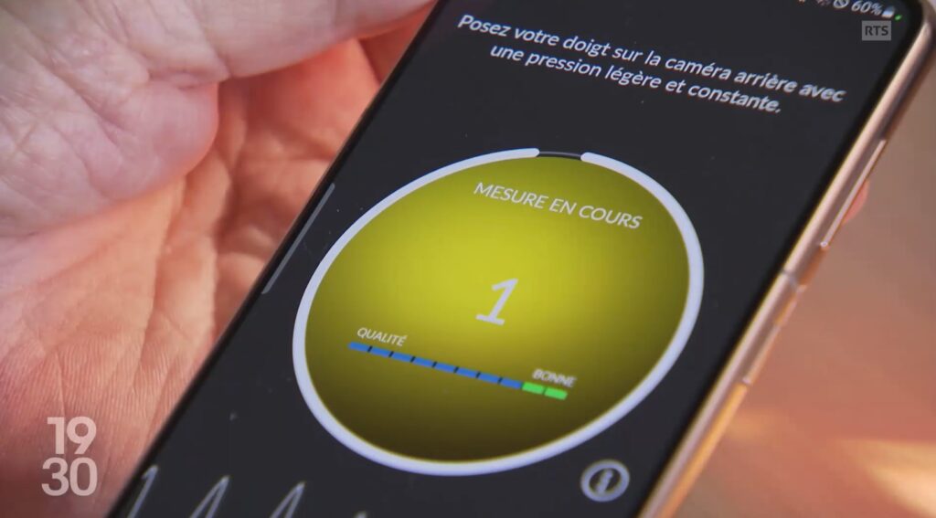 User measures their blood pressure using a smartphone with the OptiBP app for Android.